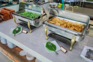 a kitchen counter with a buffet with food on it at Billiton Hotel in Tanjungpandan