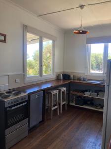 a kitchen with a counter top and two windows at Twilight Cottage in Esperance