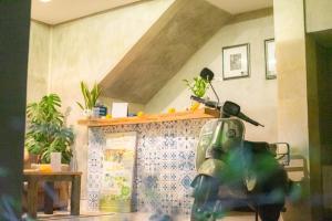a green motorcycle parked in a room with plants at Arana Garden Ubud in Ubud