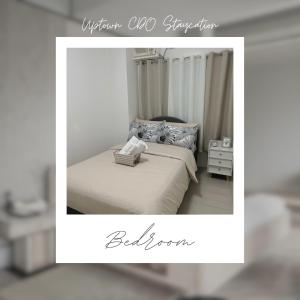 a picture of a bedroom with a bed and a sign at Uptown CDO Staycation in Cagayan de Oro