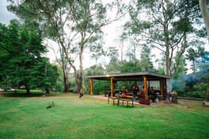 a pavilion with people sitting in it in a park at Alpine Riverside Cottages in Porepunkah
