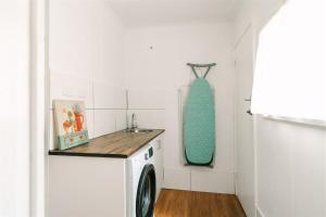 a laundry room with a washing machine and a sink at Alpine Riverside Cottages in Porepunkah