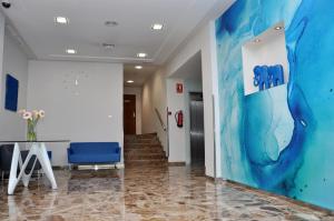 a hallway with a blue chair in a building at Hotel Castilla Alicante in Alicante