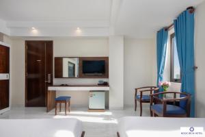 Ngọc Bích Hotel Da Nang في دا نانغ: غرفة معيشة بها أريكة وكراسي وتلفزيون