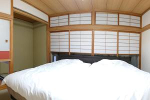 a bedroom with a white bed and a window at 眺めのいい一軒家 in Tokyo