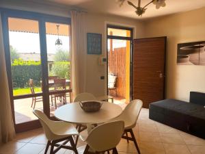 een woonkamer met een tafel, stoelen en een bank bij Feli Holiday Home - Panoramic pool lake view in Gardone Riviera in Gardone Riviera