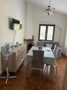 comedor con mesa, sillas y TV en Villa Maddy en Vibonati