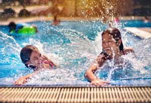 two young children playing in a swimming pool at Ngọc Bích Hotel Da Nang in Da Nang