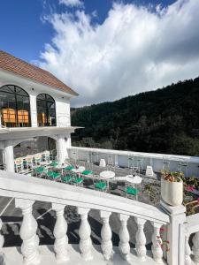 a balcony with tables and chairs on a building at Casa Rani Hotel & Restaurant in Kubupenlokan