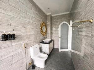 La salle de bains est pourvue de toilettes blanches et d'un miroir. dans l'établissement Casa Rani Hotel & Restaurant, à Kubupenlokan