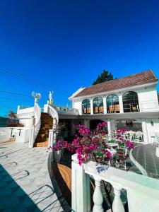 une maison blanche avec des fleurs sur une terrasse dans l'établissement Casa Rani Hotel & Restaurant, à Kubupenlokan