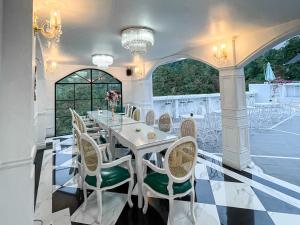 une salle à manger blanche avec une table et des chaises dans l'établissement Casa Rani Hotel & Restaurant, à Kubupenlokan