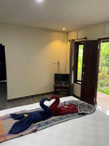 a bedroom with a bed with a towel on it at Oemah Omang Guest House Manggissari in Pulukan +5 photos