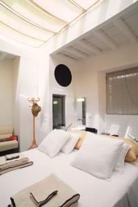 um quarto com uma grande cama branca com almofadas brancas em Ninù Roma centro storico em Roma