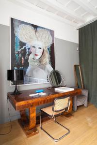 a desk with a mirror and a painting of a woman at Ninù Roma centro storico in Rome