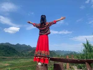 a woman standing on a fence with her arms outstretched at Mộc Châu Peachy Garden in An Pon