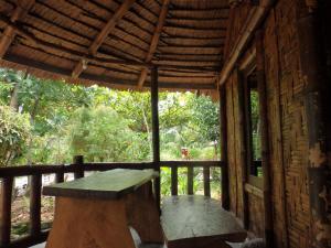 a wooden porch with a bench in a building at Magpie homestay in Bukit Lawang