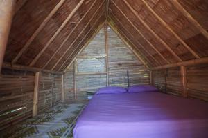 Zimmer mit einem Bett im hölzernen Dachgeschoss in der Unterkunft Redang Campstay Bamboo House in Pulai Redang