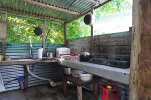 uma cozinha com um balcão e um lavatório num quarto em Redang Campstay Bamboo House em Redang Island