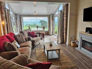 sala de estar con sofá y chimenea en Sewin Cottage en Carmarthen