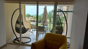 a living room with a yellow couch and a balcony at Paradise apartment, private beach condo Bay View Grand in Puerto Vallarta