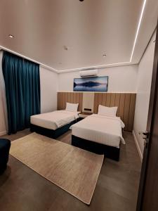 Habitación de hotel con 2 camas y TV en شاليهات راف, en Khamis Mushayt