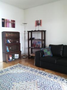 uma sala de estar com um sofá preto e uma estante de livros em Pension TimeOut em Kassel
