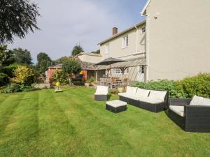 a yard with two couches and a house at Crablake Farmhouse in Exeter