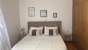 a bedroom with a bed with two tables and two pictures on the wall at Blue Paradise Apartment in Lukovë