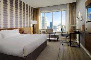 una camera d'albergo con letto, scrivania e finestra di Rotterdam Marriott Hotel a Rotterdam