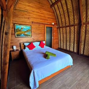 una camera da letto con un grande letto in una camera in legno di Manik Tirta Cabin's a Kintamani