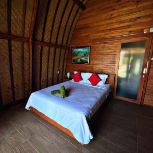 Manik Tirta Cabin's في Kintamani: غرفة نوم بسرير في كابينة خشبية