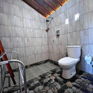 a bathroom with a toilet in a room at Manik Tirta Cabin's in Kintamani