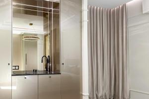 a bathroom with a shower curtain and a sink at Monaco Premium Suites - NEW in Monte Carlo