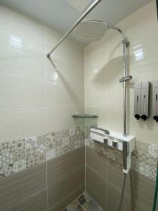 a bathroom with a shower with a glass door at Soldongsan Stay in Seogwipo