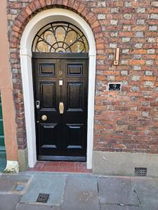 a black door on the side of a brick building at Carlisle City Centre The Gavel in Carlisle