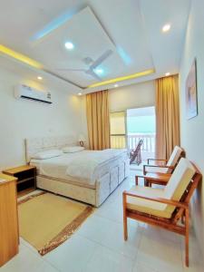 a bedroom with a large bed and two chairs in it at SEA VILLAS Salalah in Salalah