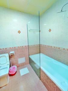 a bathroom with a shower and a tub and a toilet at SEA VILLAS Salalah in Salalah