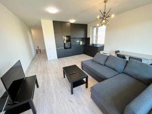 a living room with a couch and a table at FREE 2X parking and free Wifi NEW Suncatcher apartment in Bratislava