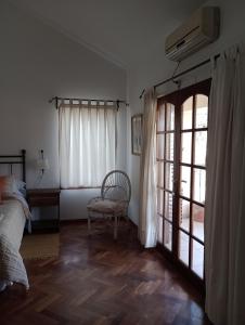 1 dormitorio con 1 cama, 1 silla y 1 ventana en Nueva Morada en Córdoba