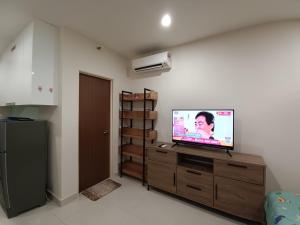 a living room with a flat screen tv on a dresser at Infinity Pool at Kozi Square Homestay in Kuching
