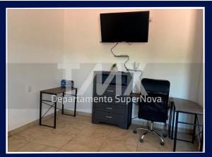 d'un bureau, d'une chaise et d'une télévision murale. dans l'établissement TMX HOSTAL, à Puerto Escondido