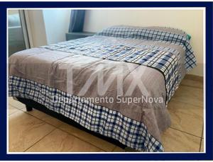 Una cama con una manta encima. en TMX HOSTAL, en Puerto Escondido