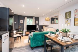 a living room with a green couch and a table at 5-bedroom Haven, Perfect For Business And Leisure in Canterbury