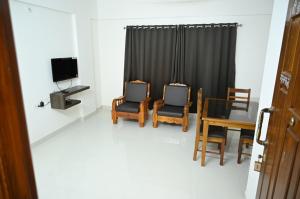 sala de estar con 2 sillas y TV en Udupi Kshetra en Udupi