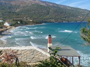 a lighthouse on a beach next to a body of water at Blue Bay Beach Hotel in Koinyra