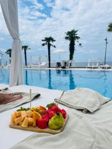 a plate of fruit on a table next to a pool at Dreamland Oasis Apartment 614 in Chakvi