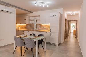 a white kitchen with a table and chairs at Fancy Modern APT Sliema - w/ 2BR in Sliema