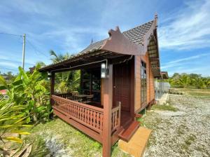 a small house with a porch and a roof at Rumah Kebun Gucher in Kuala Terengganu