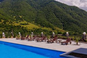 a pool with chairs and a mountain in the background at Dream Hotel in Haghpat